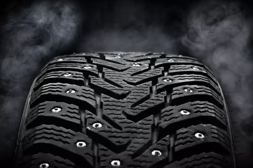 winter studded tyre dark moody. steam on background. studio shot. tyres industry concept. copy space